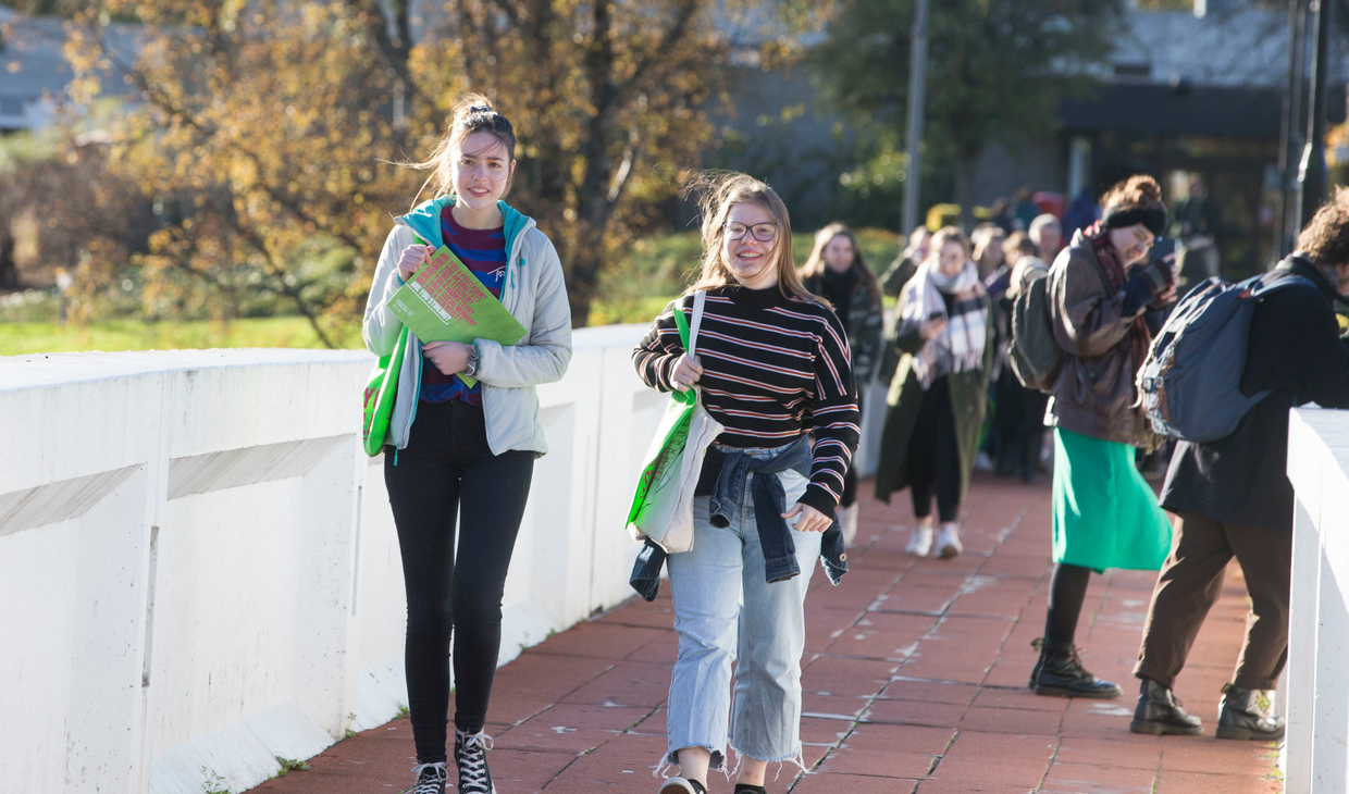Two girls walking across bridge on University of Stirling campus during an Open Day