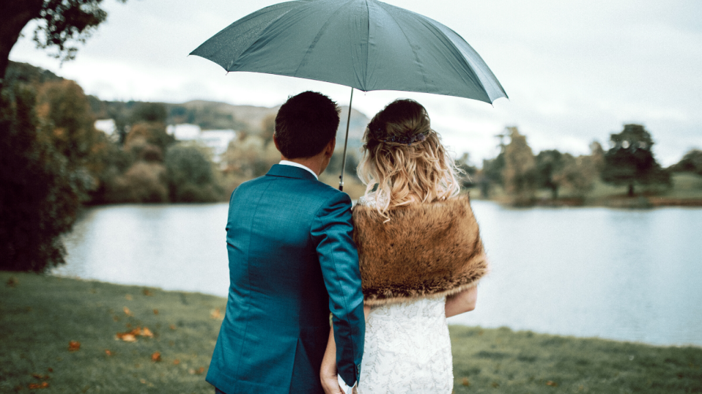 Couple with umbrella looking over loch on the university campus