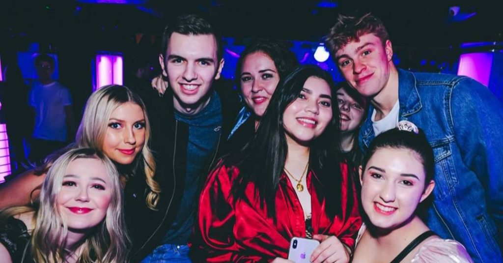 Group of students smiling on a night out