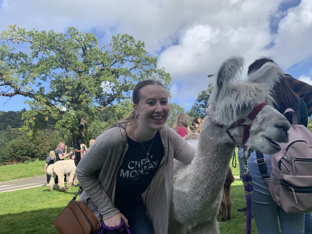 Emily smiling next to an alpaca