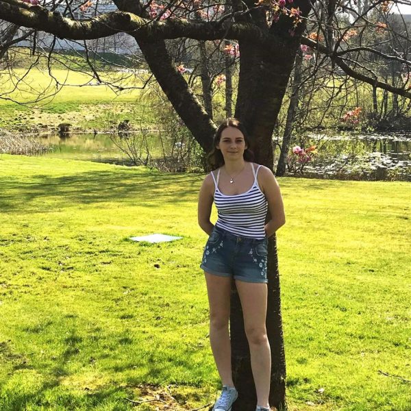 Megan Perry outside leaning on a tree