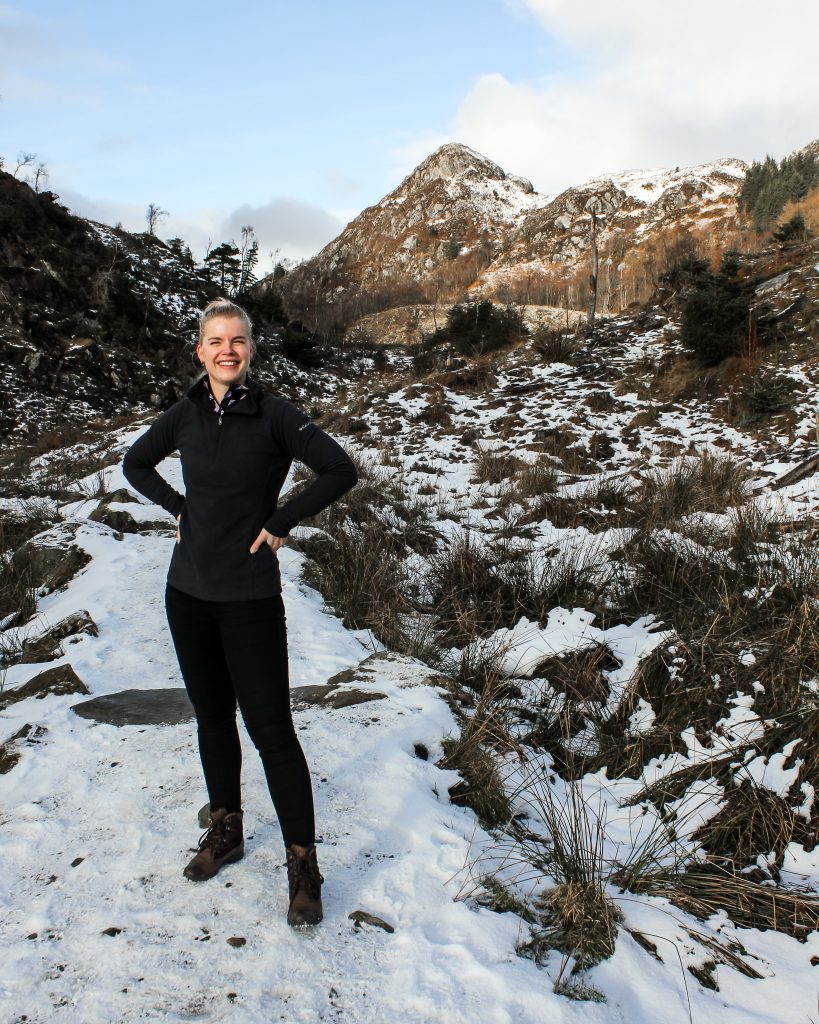 Woman standing in front of snowy mountain. 