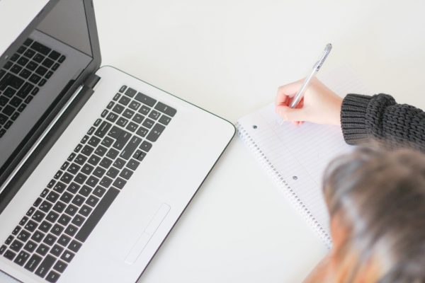 A young person about to write a UCAS Personal Statement. A laptop is open in front.