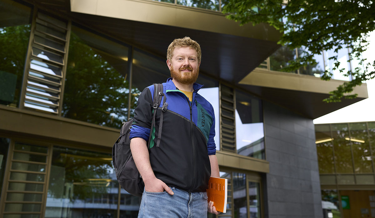 Male student standing outside campus central