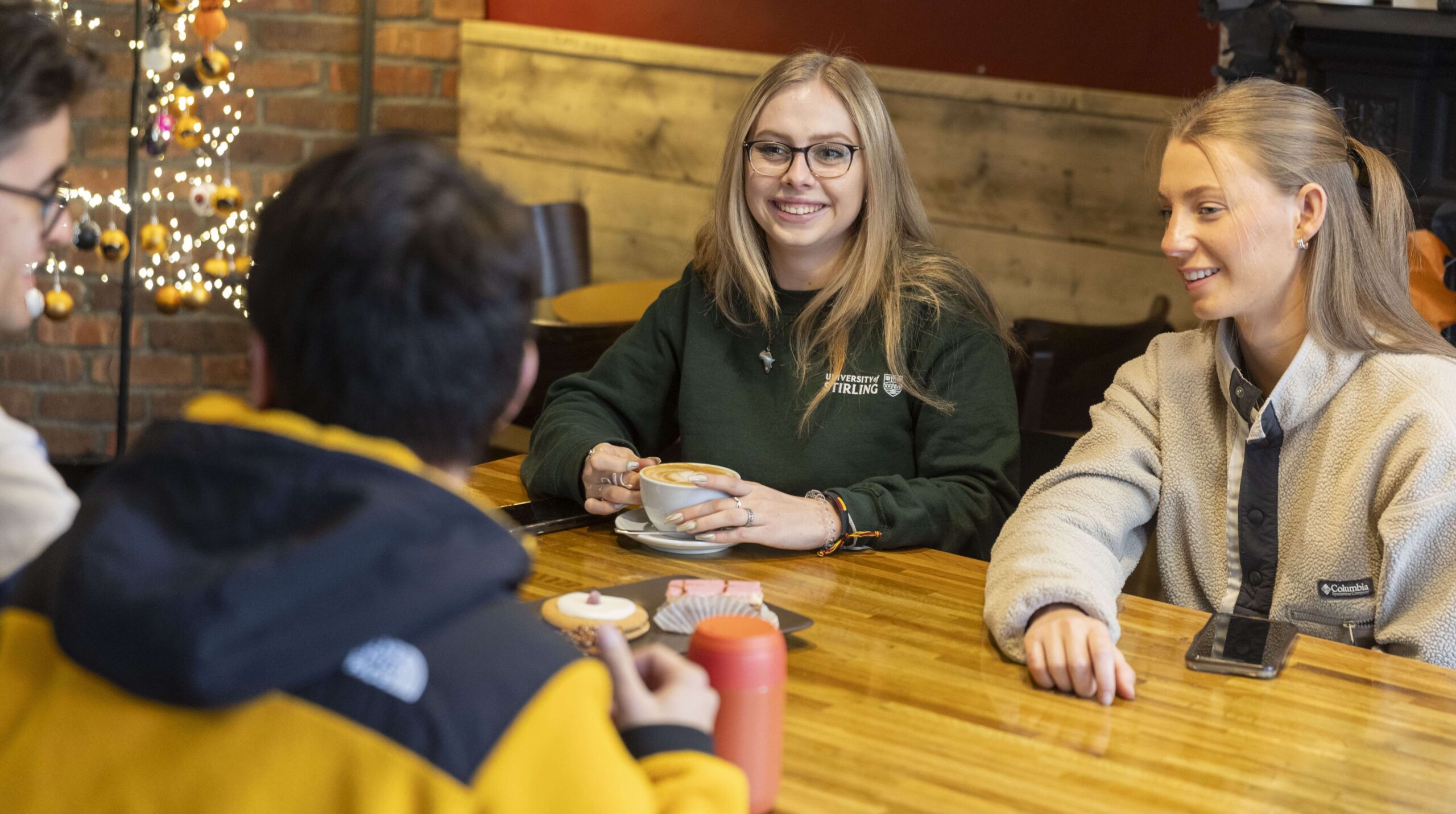 Four students sitting together in a coffee shop